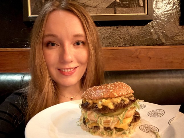 Courtney Pochin holding the Big Matt burger on a plate at Hawksmoor restaurant