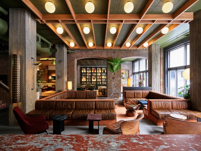The 1970s inspired foyer of Ace Hotel Sydney, with large bulbs in the ceiling and warm, wooden decor