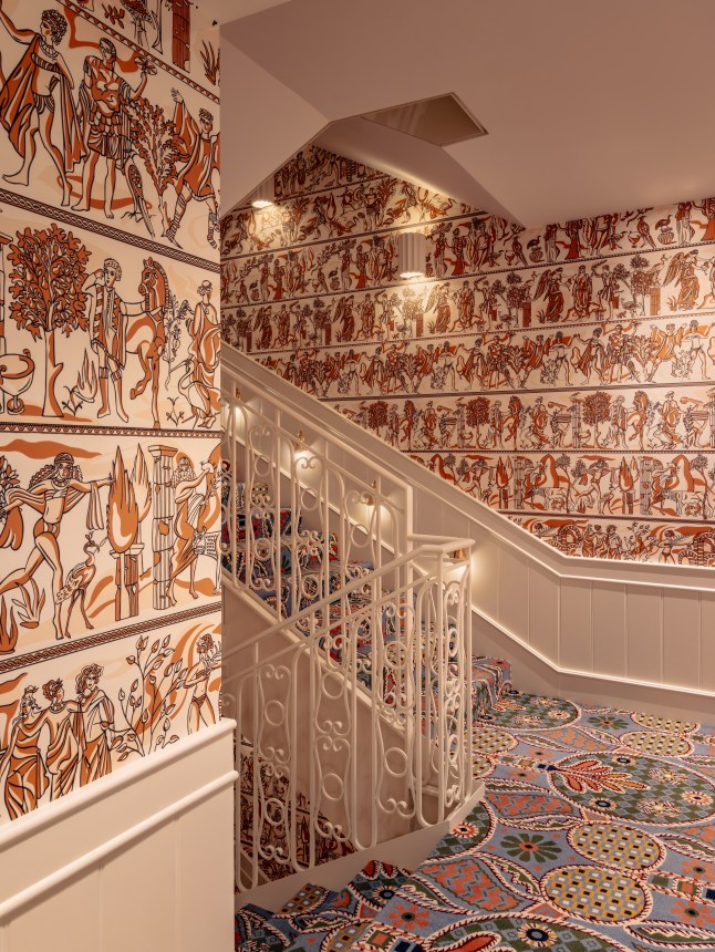 A shot of the stairwell at Casa Monti Roma Hotel, with beautiful wallpaper and a maximalist carpet