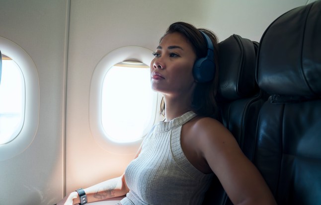 Woman anxious and frightened on a plane, wearing headphones