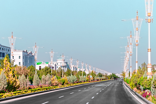 Urban city scape of Ashgabat city center with wide highway and light traffic. High white marble buildings by sides. Ashgabat is the capital of Turkmenistan