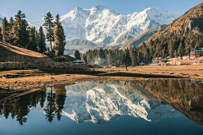 A snowcapped mountain range in Nanga Parbat in northern Pakistan, with a large lake in front of it.