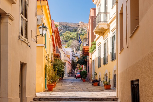 A pretty street in the Plaka historic district of Athens, Greece, with the Acropolis in the distance.