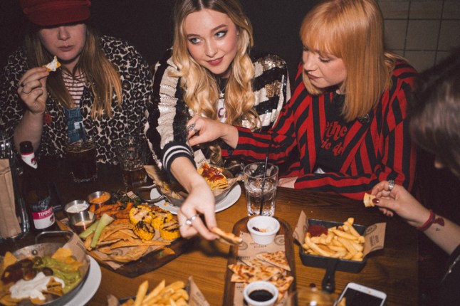 A group of women eating food late at night at a restaurant