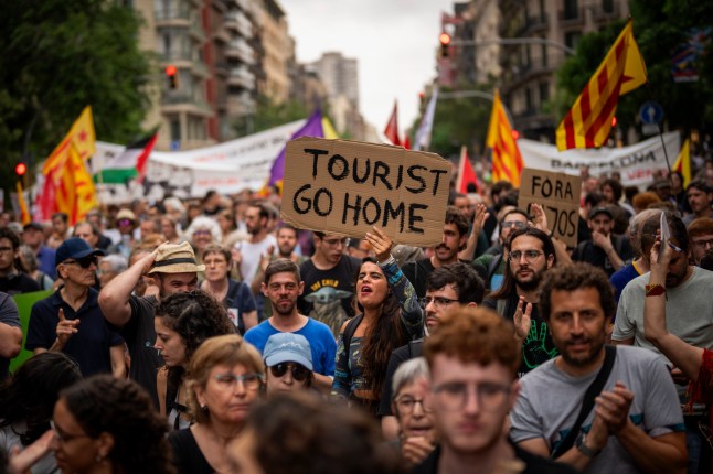 Demonstrators march shouting slogans against the Formula 1 Barcelona Fan Festival in downtown Barcelona, Spain, Wednesday, June 19, 2024, during residents protest against mass tourism