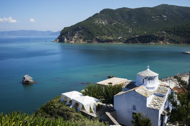 Whitewash Church With A View Of The Coastline And The Aegean Sea. Skopelos Town, Skiathos, Greece.