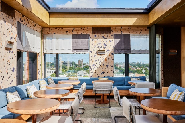 The rooftop restaurant Kiln inside the Ace Hotel Sydney, with a retractable roof pulled open