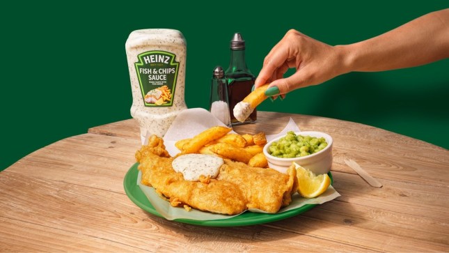 A plate of Fish and Chips with Heinz new Fish & Chips Sauce, a hand is dunking a chip in the condiment