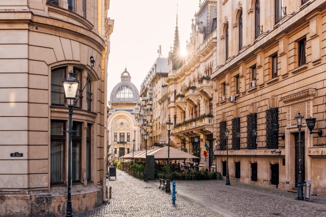 A quiet cobbled street with Renaissance-style buildings in Bucharest, Romania.