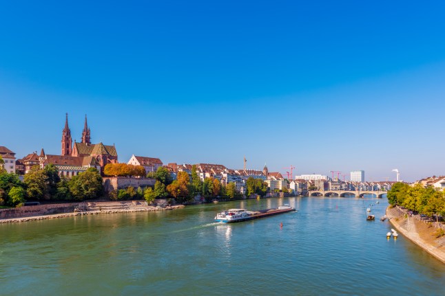 The skyline of the city of Basel, Switzerland alongside the River Rhine, on a clear bright day.