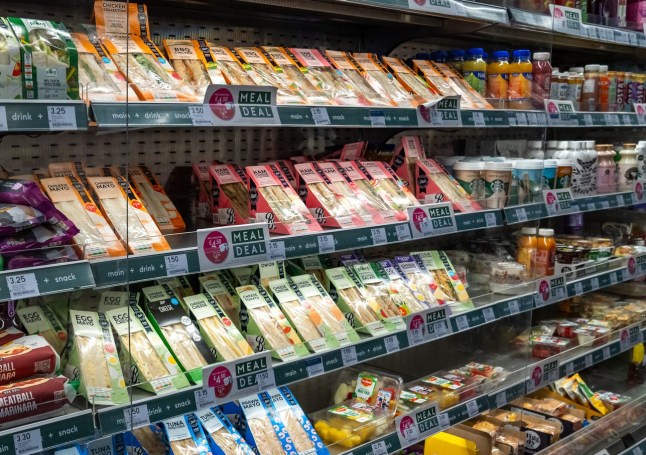 A Supermarket Shelf Displays Pre Packaged Sandwiches, Snacks, and Beverages, Offering Quick Meal Deals for Shoppers.