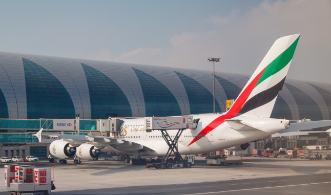 An Emirates plane parked on a finger of Dubai International Airport in the UAE.
