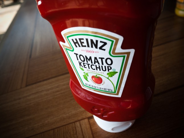 A bottle of Heinz Tomato Ketchup on a wooden table