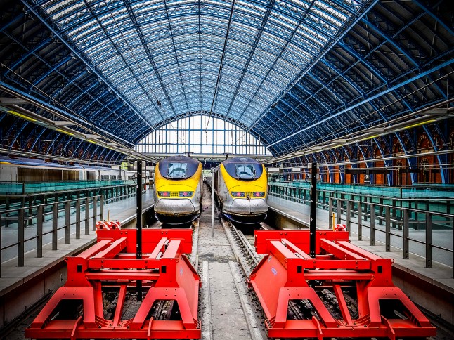 Two yellow trains sitting in a platform at London St Pancras rail station.