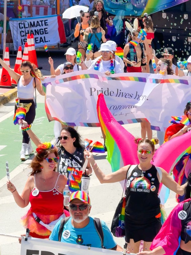 People march in colourful clothes with LGBTQ+ positive banners at the Miami Beach Pride parade