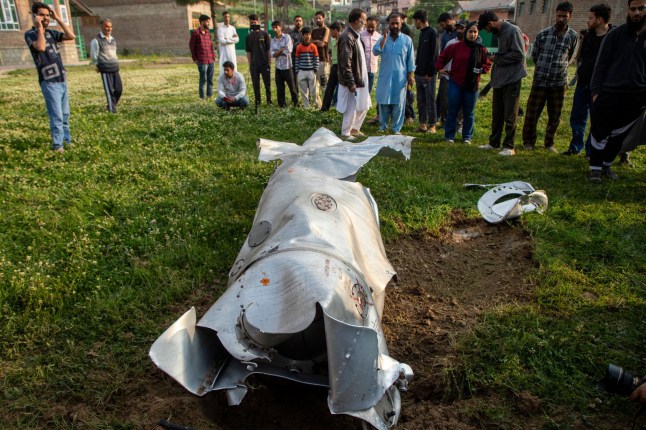 People look at a part of a unknown crushed aircraft in Wuyan near Indian-administered Kashmir's main city of Srinagar. India fired missiles at Pakistani territory early on May 7, killing at least eight people, according to Pakistan, which said it had begun retaliating in a major escalation between the nuclear-armed rivals. India-Pakistan on Edge of War Over Kashmir Attack