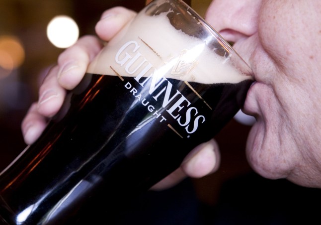 A man drinks a pint of Guinness